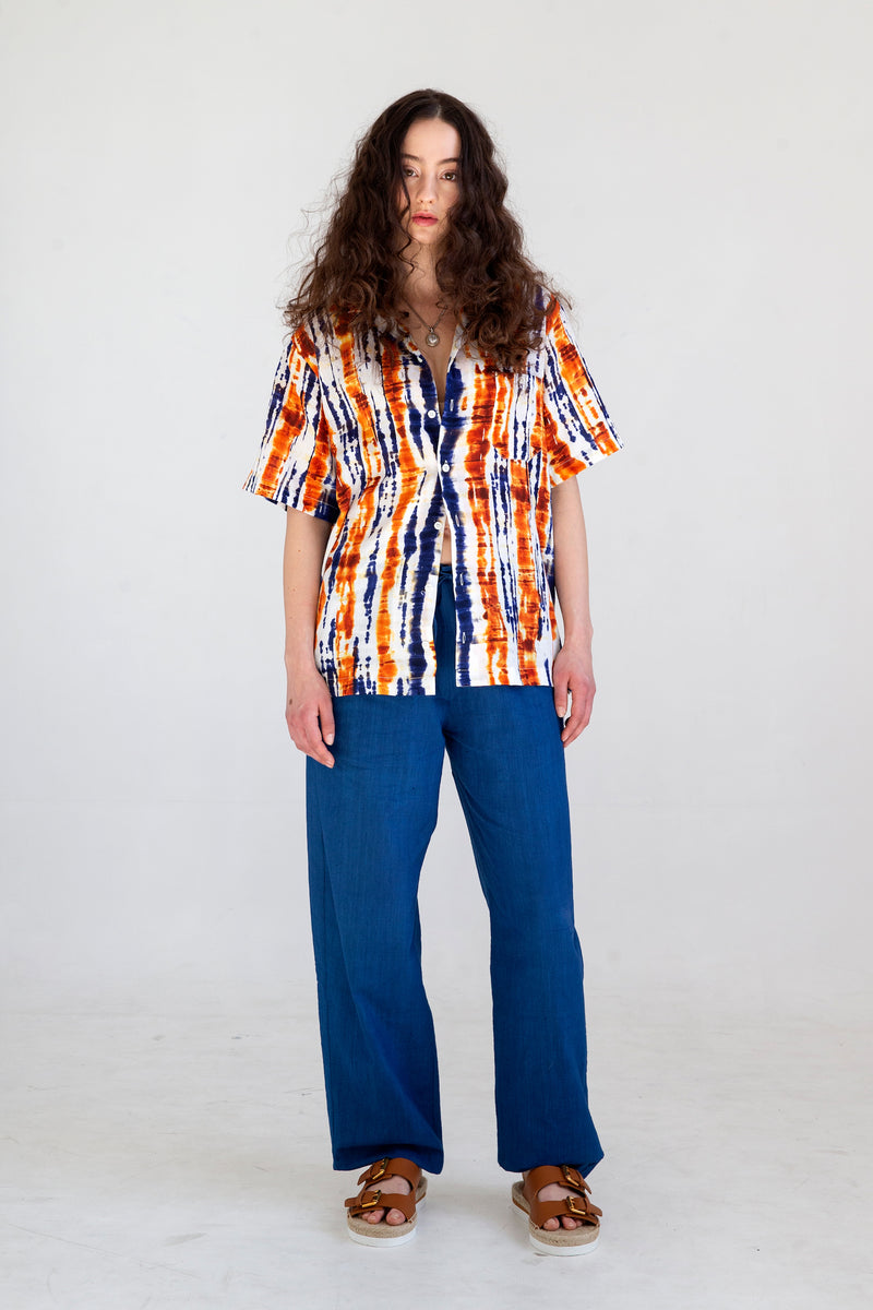 blue and orange short sleeve camp collar shirt over blue pants